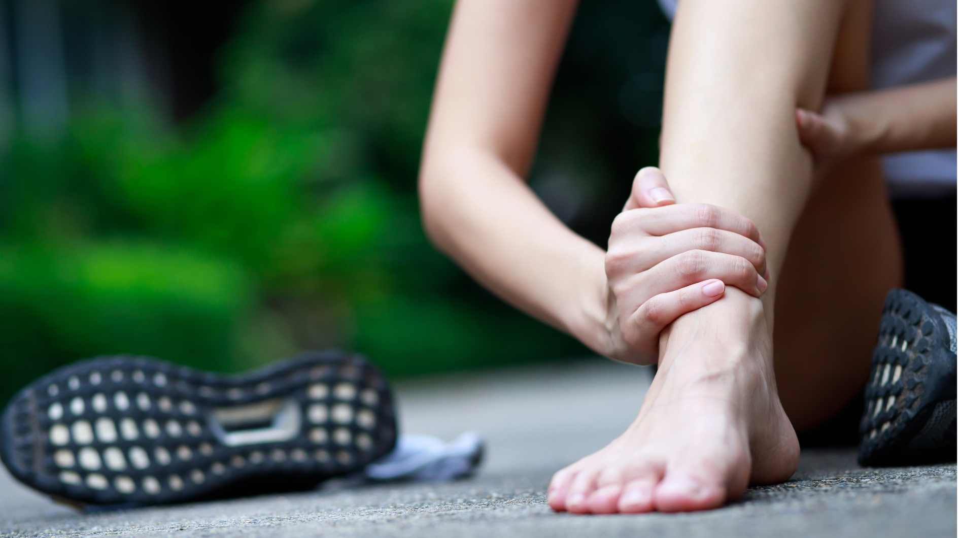 athletic person grasping their leg experiencing a painful muscle spasm