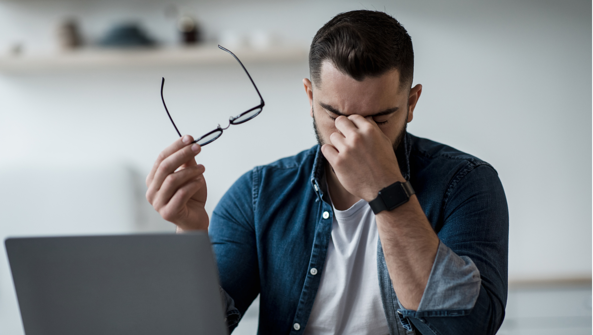man at work desk grasping head needing tension headache treatment